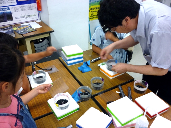 Dr. Junpei Fujimoto of KEK shows kids a hands-on experiment – a cloud chamber where you can actually see particles